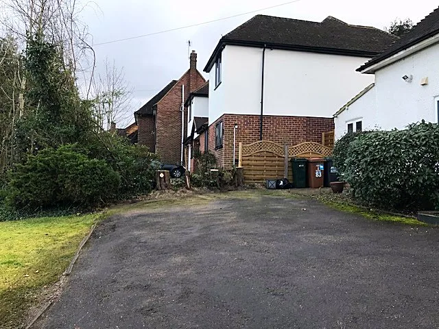 Branch Walkers Tree Surgery: Overgrown hedge and trees beside a house and driveway before cutting back near Northwood